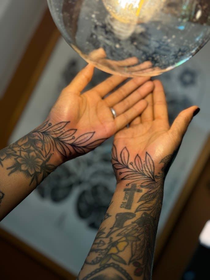 Primer plano de la mano de un tatuador profesional dibujando patrones tradicionales intrincados en papel de pergamino de alta calidad