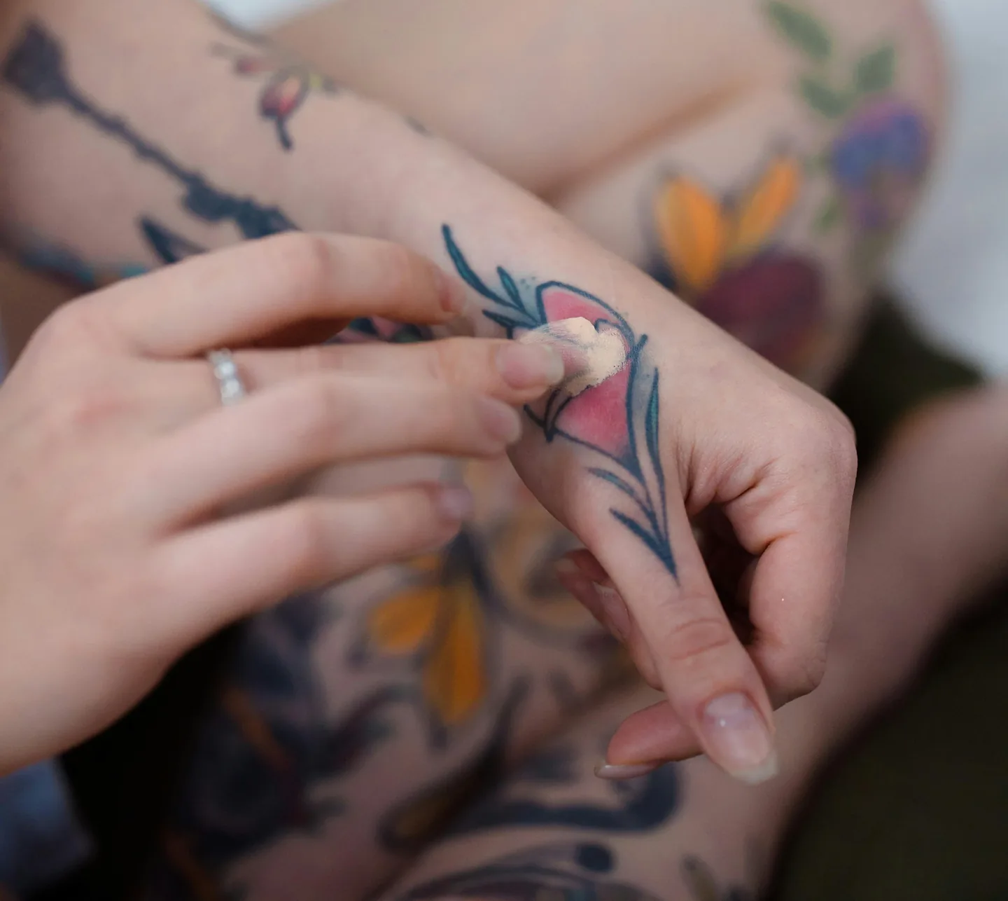 A macro shot focusing on the delicate process of cleaning a fresh tattoo with a soft cloth and clear soap